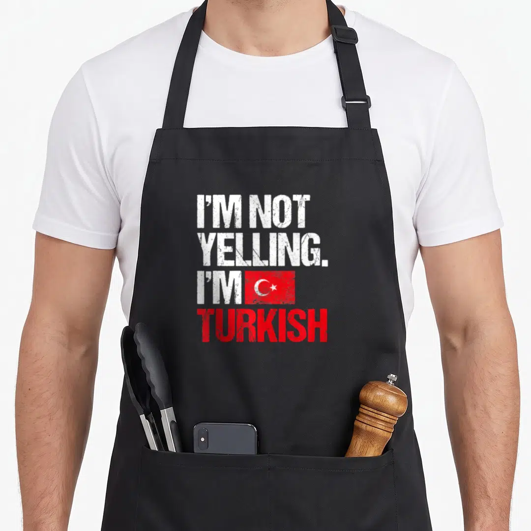 Yelling turkey apron - Distressed white and red text I'm Not Yelling I'm Turkish with flag graphic — shown on a black cotton canvas apron against a white background