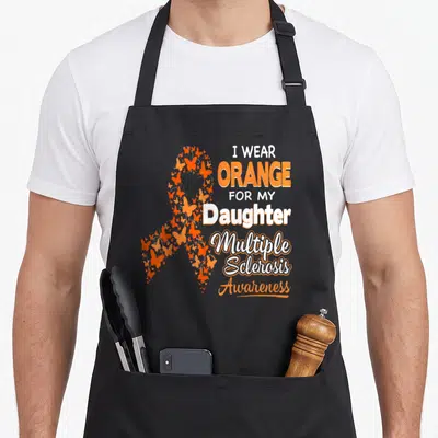 Daughter multiple sclerosis awareness apron - Orange butterfly awareness ribbon with stacked text reading I wear orange — shown on a black cotton canvas apron against a white background