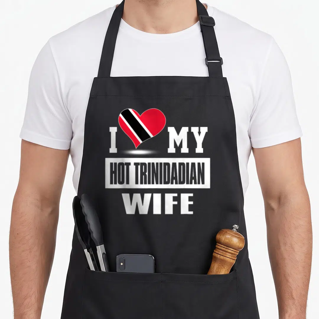Trinidadian wife apron - I MY HOT TRINIDADIAN WIFE text with red black white heart on black apron — shown on a black cotton canvas apron against a white background