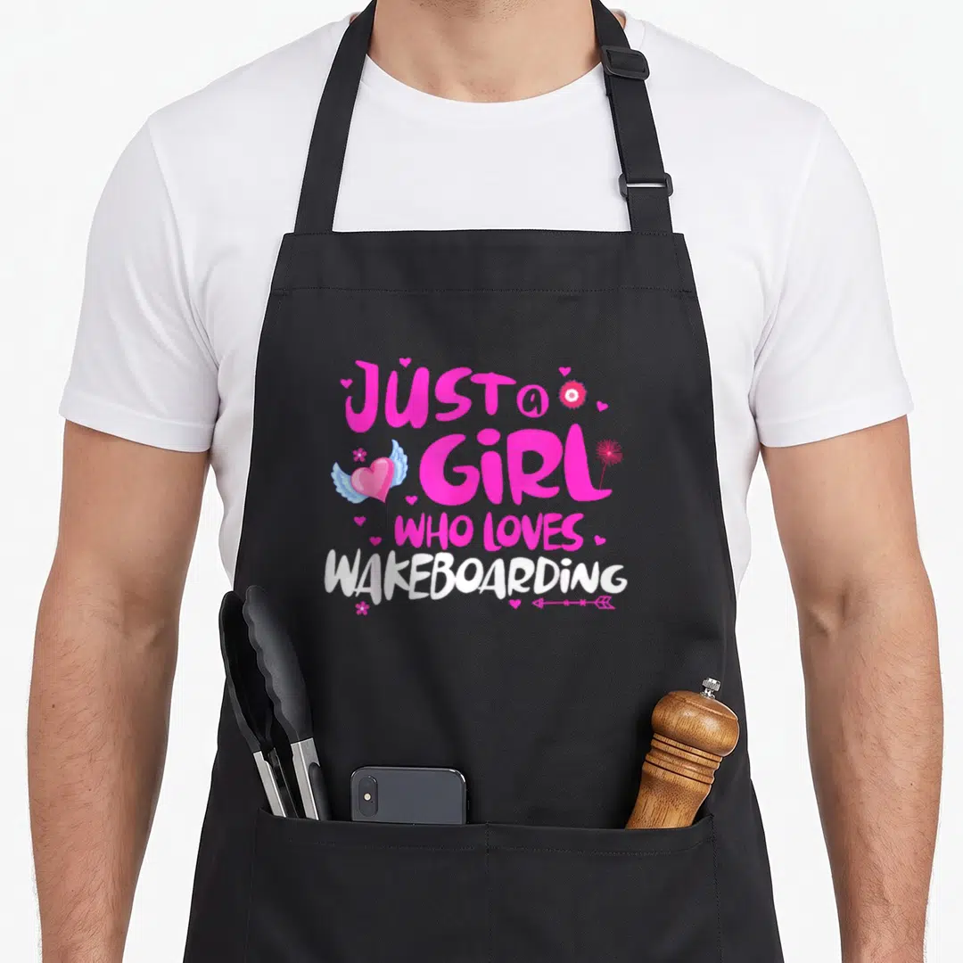 Funny wakeboarding apron - Pink and white text with blue winged heart, flower, and arrow on grey background — shown on a black cotton canvas apron against a white background
