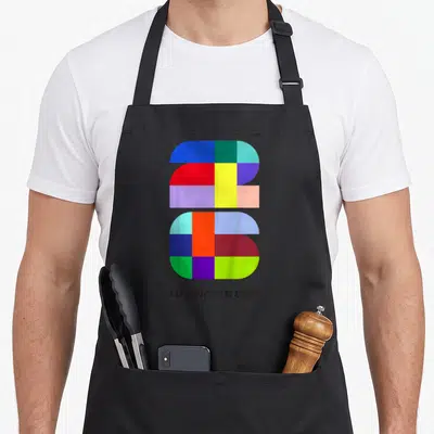 Fifa grade soccer apron - Multicolored geometric 26 graphic with FIFA WORLD CUP text in blue red yellow green purple — shown on a black cotton canvas apron against a white background