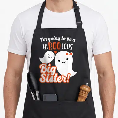 Sister halloween apron - Two white ghosts with orange bow and heart surrounding FABOO LOUS Big Sister text — shown on a black cotton canvas apron against a white background