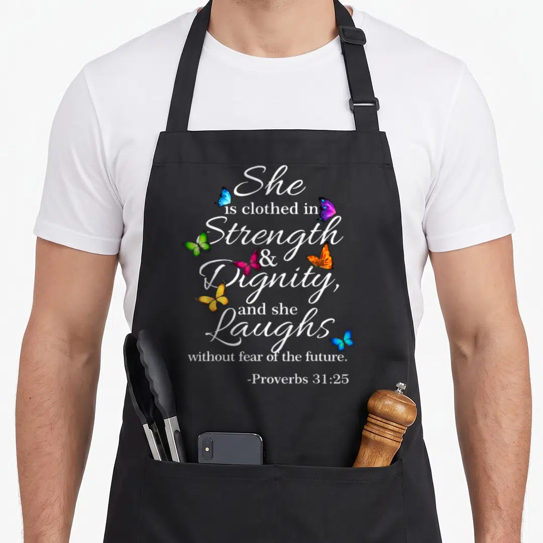 She woman religious apron - White Proverbs 31:25 text surrounded by five blue purple green orange and pink butterflies — shown on a black cotton canvas apron against a white background
