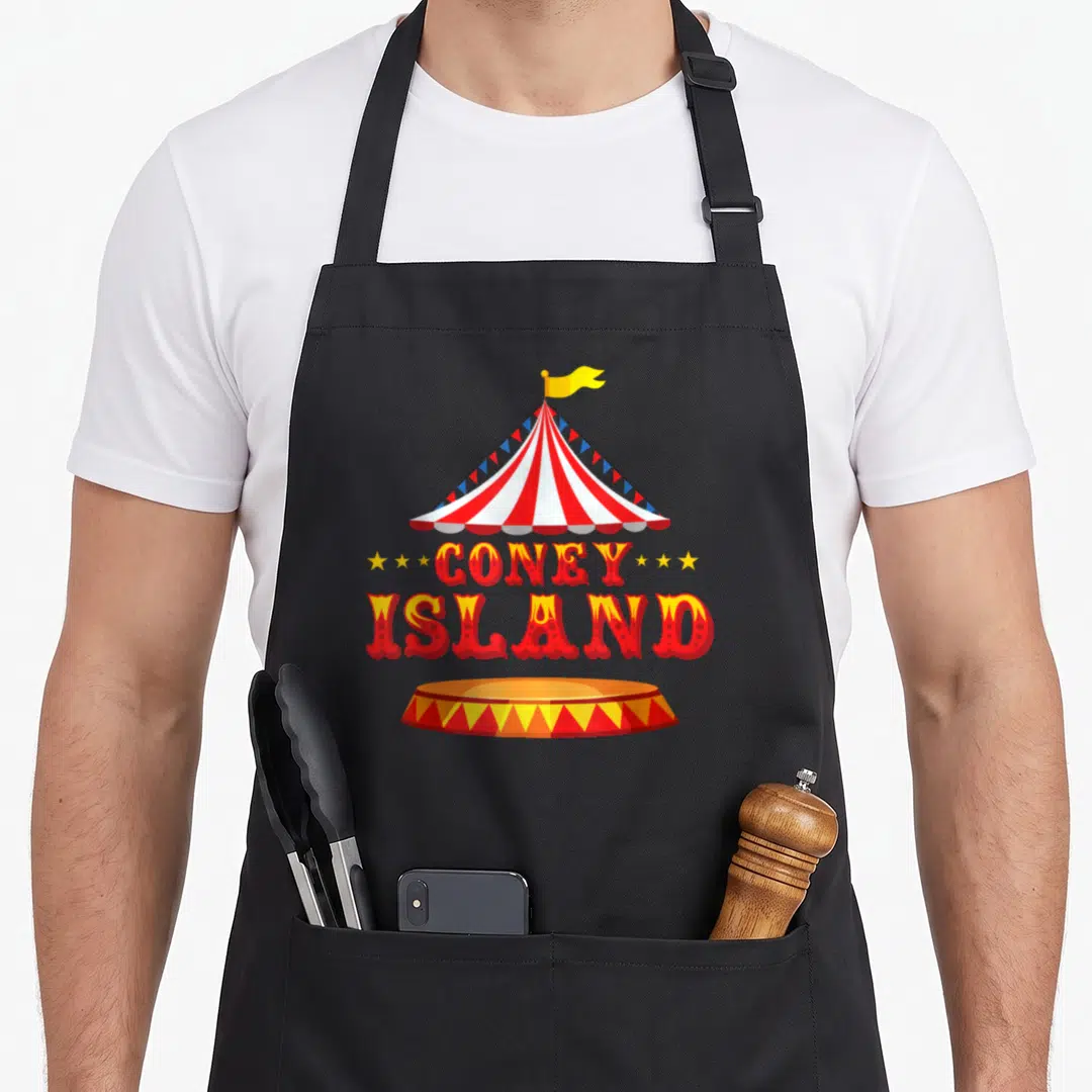 Coney new york apron - Red and white circus tent with Coney Island text and ring base — shown on a black cotton canvas apron against a white background