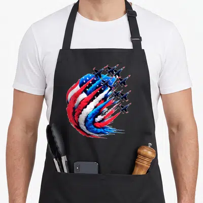 Sky 4th of july apron - Six jets leaving red white blue smoke forming waving flag — shown on a black cotton canvas apron against a white background