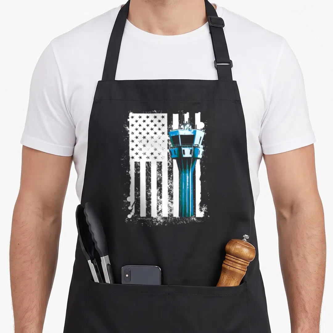 Traffic us aprons - Blue air traffic control tower graphic over distressed white US flag pattern — shown on a black cotton canvas apron against a white background
