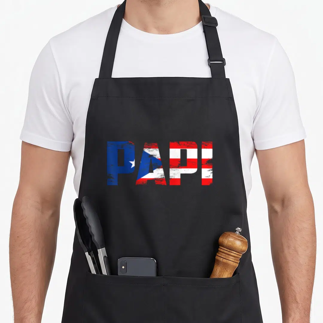 Papi father day apron - Distressed PAPI text filled with Puerto Rican flag stripes and star in blue red and white — shown on a black cotton canvas apron against a white background