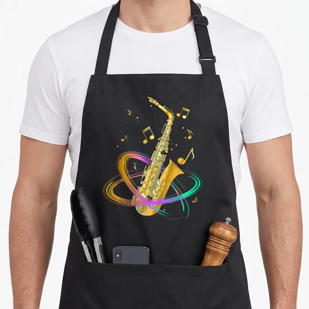 Musical jazz apron - Gold saxophone with floating notes and colorful swirling lines in orange purple blue and green — shown on a black cotton canvas apron against a white background
