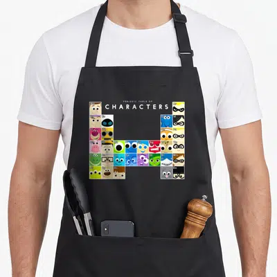 Collection table apron - Grid of colorful character faces with two-letter symbols arranged under centered text — shown on a black cotton canvas apron against a white background