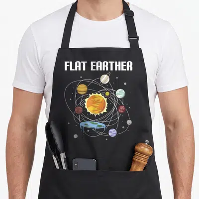 Believer earther apron - Retro flat earth solar system with dripping blue planet and white elliptical orbits under bold — shown on a black cotton canvas apron against a white background