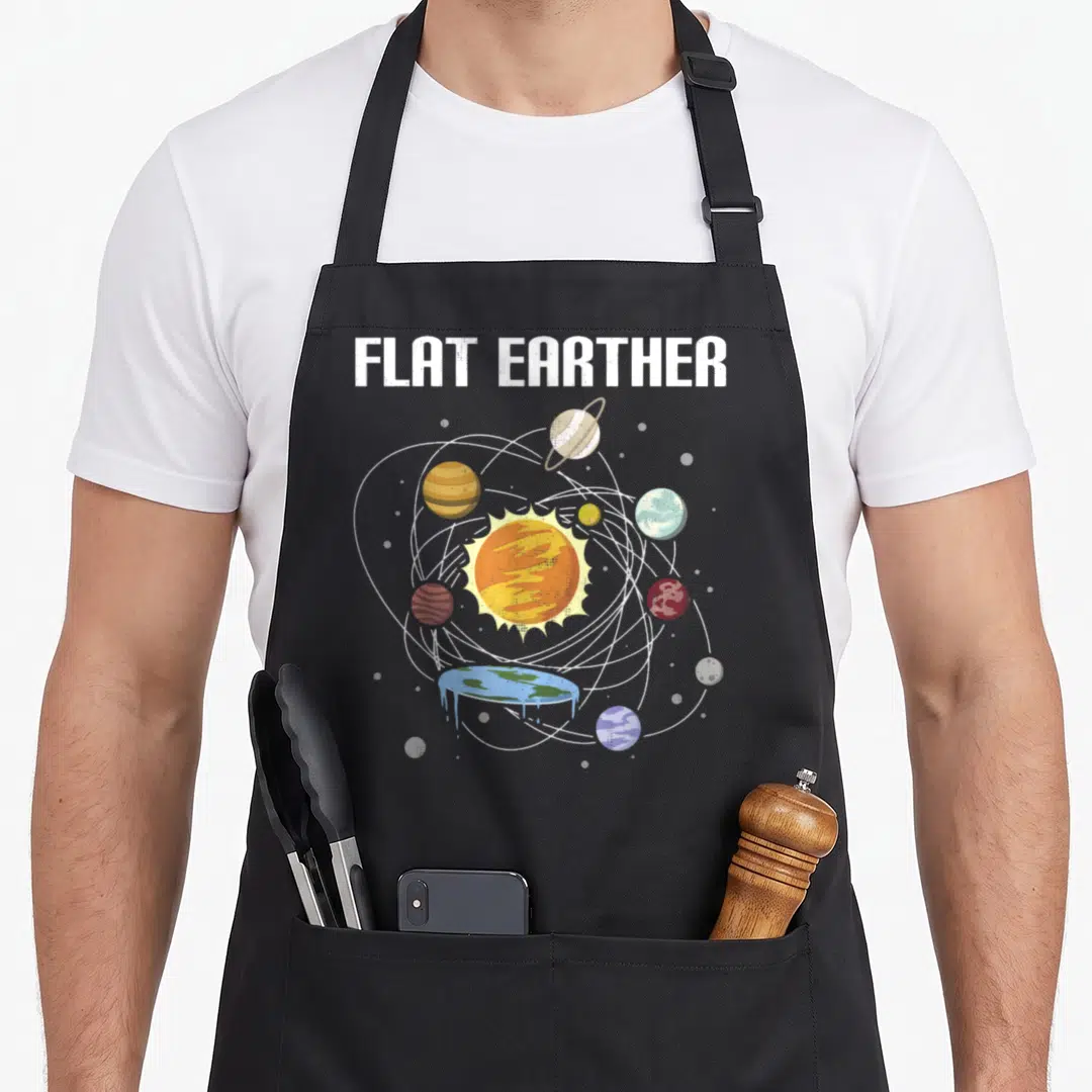 Believer earther apron - Retro flat earth solar system with dripping blue planet and white elliptical orbits under bold — shown on a black cotton canvas apron against a white background