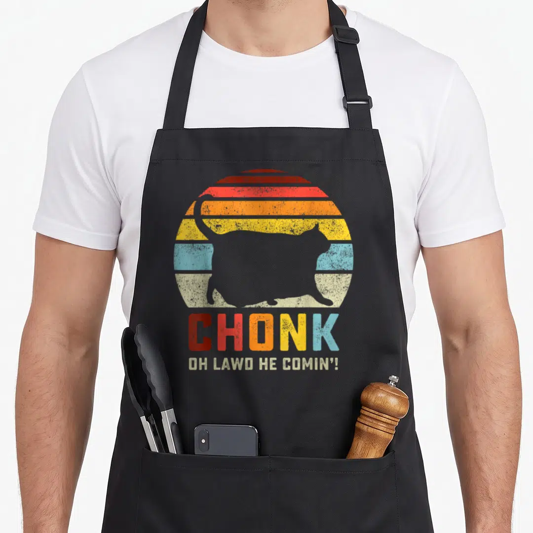 Chonk cat apron - Grey cat silhouette over red orange yellow blue striped semi-circle with stacked text CHONK OH LAWD — shown on a black cotton canvas apron against a white background
