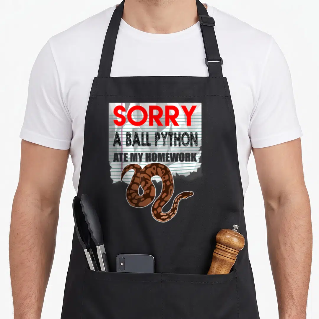 Ball pet apron - Torn lined paper with red text and coiled brown cartoon ball python — shown on a black cotton canvas apron against a white background