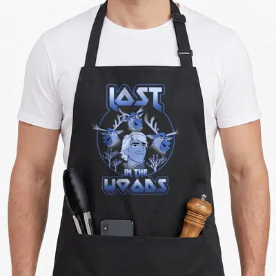 Sven wood apron - Man and three reindeer heads in blue circle with LAST IN THE WOODS text — shown on a black cotton canvas apron against a white background