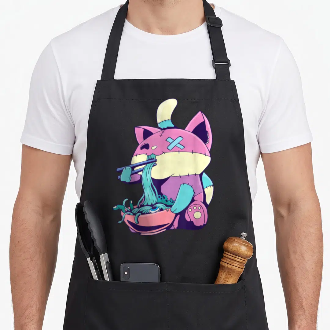 Ramen anime cooking apron - Stitched cat in purple blue pink cream eating noodles with chopsticks from a bowl — shown on a black cotton canvas apron against a white background