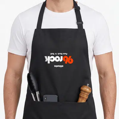 Upside atlanta apron - Inverted white and orange text reading Pure Rock n Roll rock atlanta — shown on a black cotton canvas apron against a white background