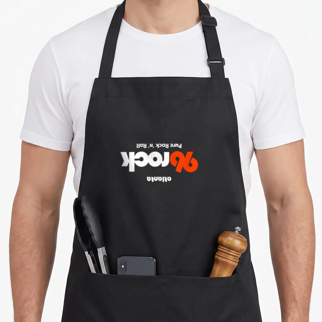 Upside atlanta apron - Inverted white and orange text reading Pure Rock n Roll rock atlanta — shown on a black cotton canvas apron against a white background