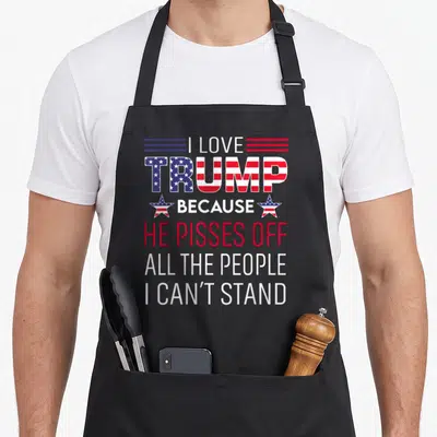 Trump piss novelty apron - Stacked red white blue text with US flag pattern in TRUMP and two stars flanking BECAUSE — shown on a black cotton canvas apron against a white background