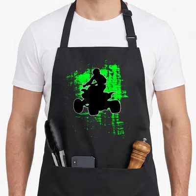 Splatter bike apron - Black ATV rider silhouette on green paint splatter background with white outline — shown on a black cotton canvas apron against a white background