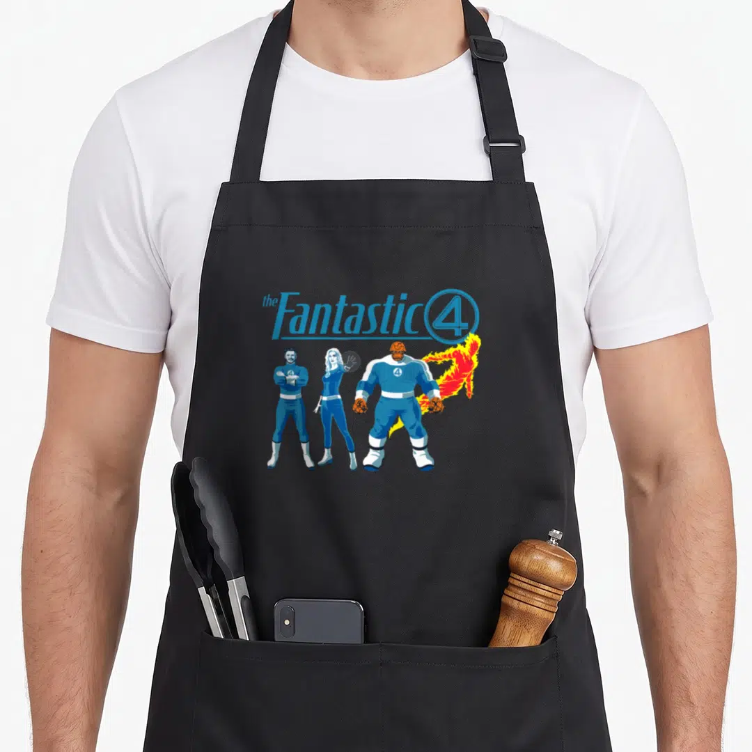 Together first steps apron - The Fantastic 4 text above four superheroes in blue suits with orange and red accents — shown on a black cotton canvas apron against a white background