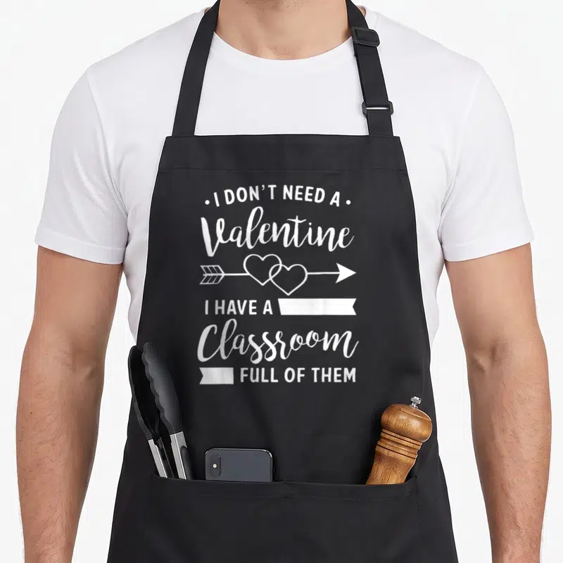 Valentine classroom aprons - I Don't Need A Valentine I Have A Classroom Full Of Them text with arrow and interlocking — shown on a black cotton canvas apron against a white background