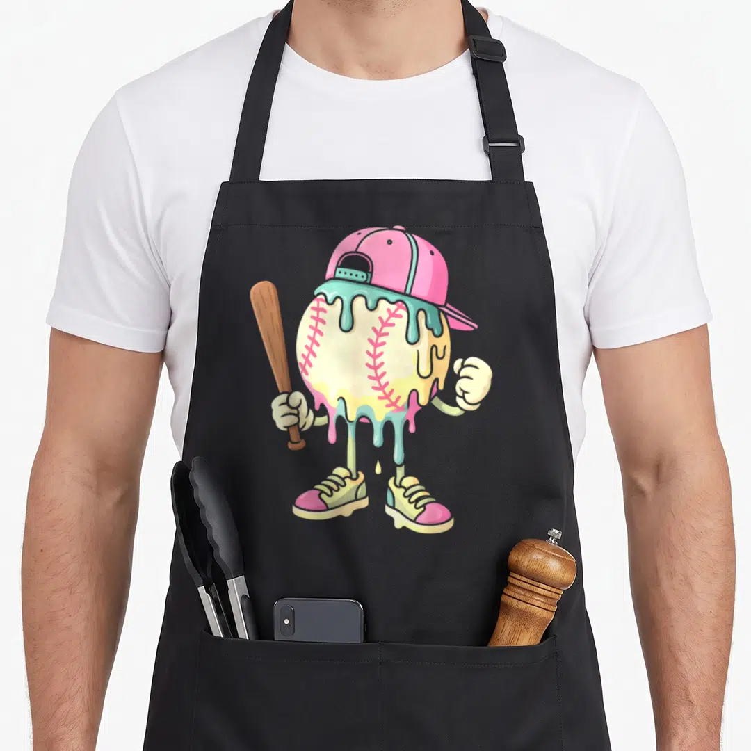 Cream drip apron - Cartoon baseball with pink cap, teal drips, cream body, pink stitches, brown bat, white gloves — shown on a black cotton canvas apron against a white background