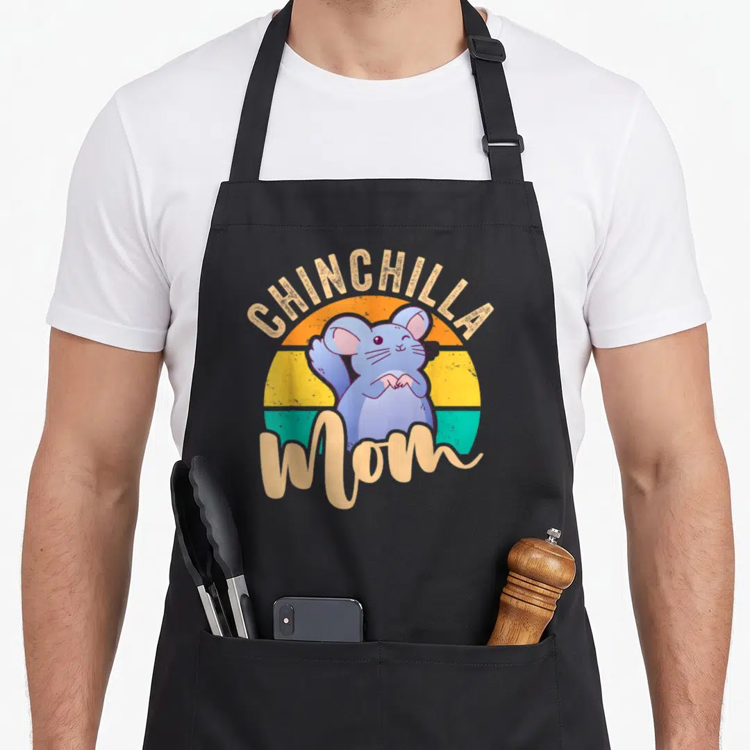 Chinchilla mom apron for women - Blue cartoon chinchilla sitting before striped sunset circle with beige text — shown on a black cotton canvas apron against a white background