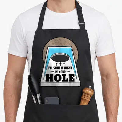 Toss bags and aprons - Cartoon cornhole board with arrows and sarcastic text I'll slide it right in your hole — shown on a black cotton canvas apron against a white background
