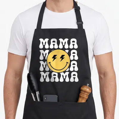 Mama custom face apron - Yellow smiley face with lightning bolt eyes over four stacked white MAMA words in retro style — shown on a black cotton canvas apron against a white background