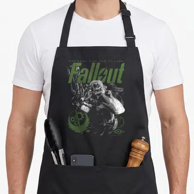 Brotherhood video game apron - Power armor soldier with green Fallout logo and gear emblem on grey background — shown on a black cotton canvas apron against a white background