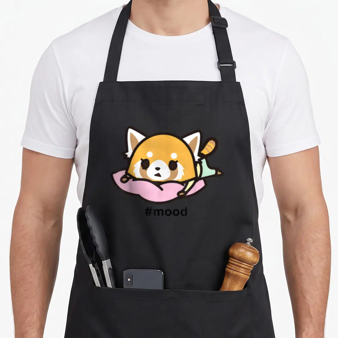 Stressed novelty apron - Cartoon red panda lying on pink pillow with #mood text below — shown on a black cotton canvas apron against a white background
