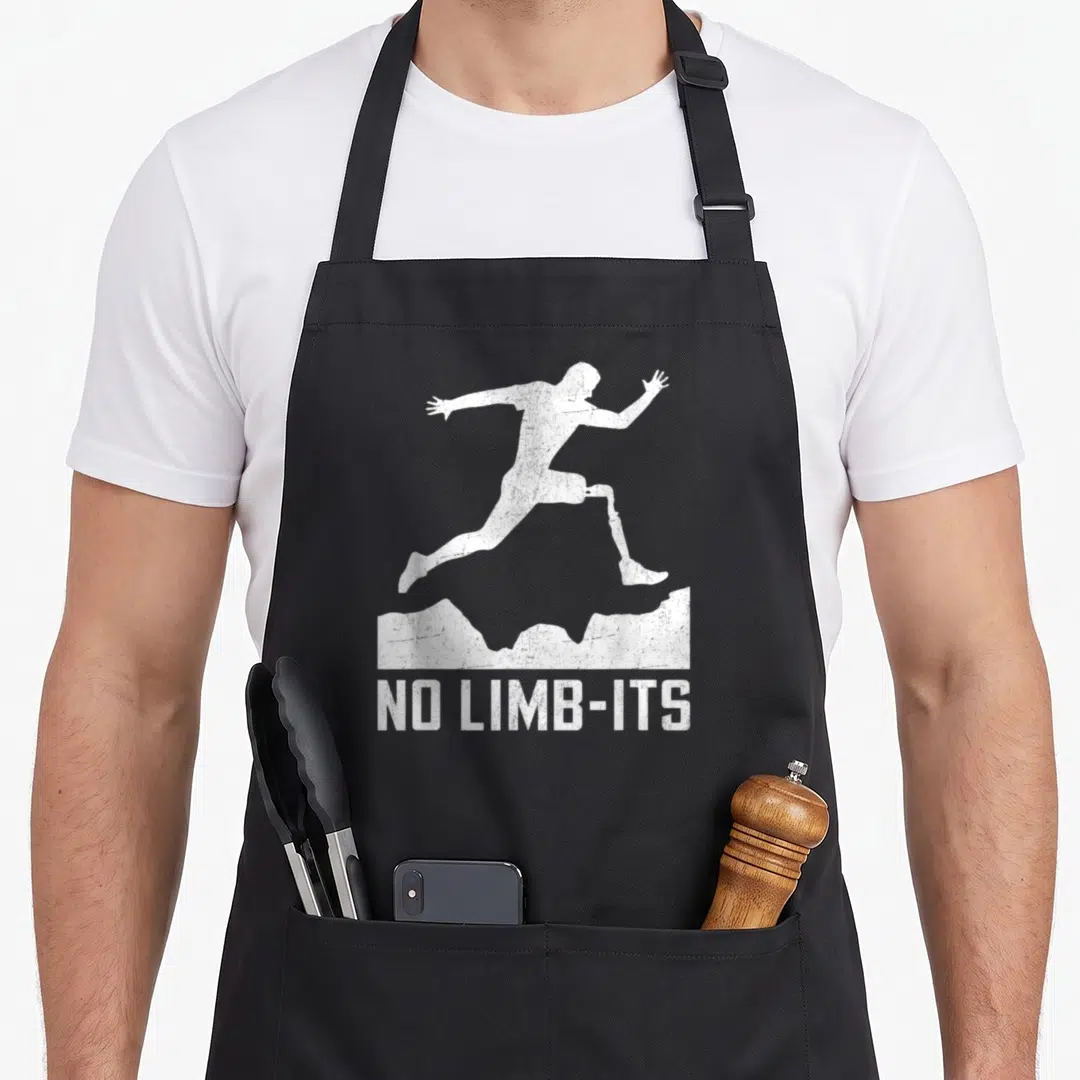 Limb tronic apron - White runner with prosthetic leg leaping over mountain, NO LIMB-ITS text below — shown on a black cotton canvas apron against a white background