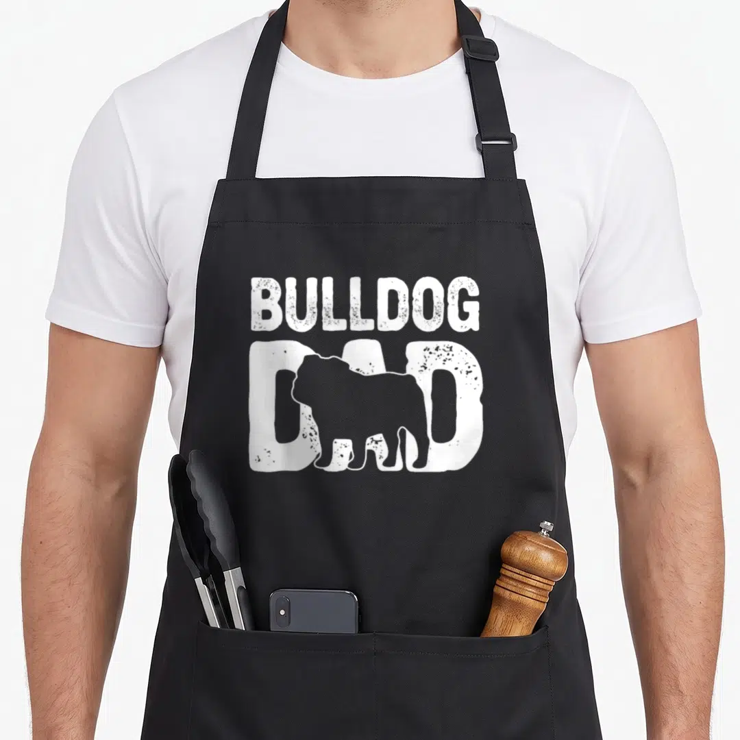Bulldog english dog apron - White BULLDOG DAD text with bulldog silhouette overlay on grey distressed background — shown on a black cotton canvas apron against a white background