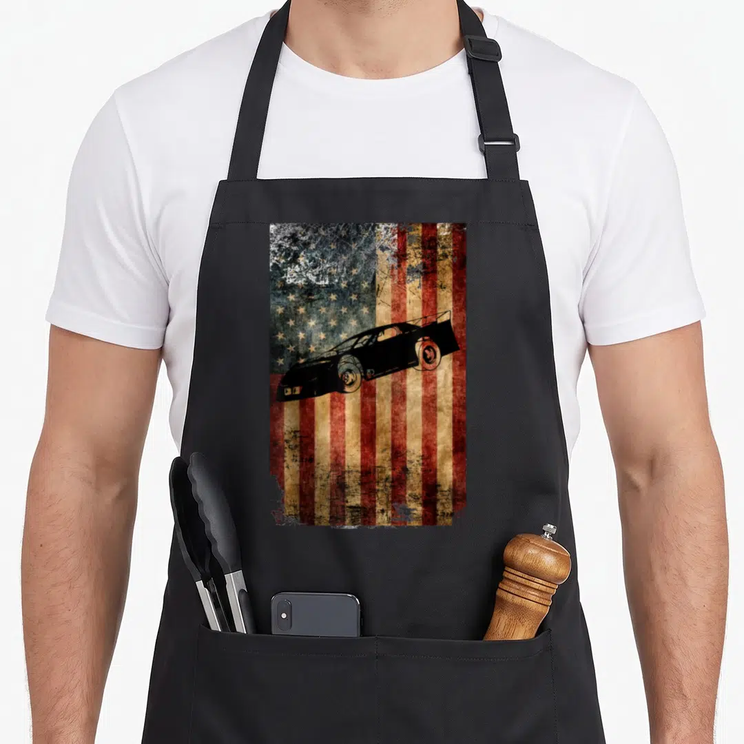 Late american flag apron - Black late model race car silhouette over distressed red white and blue flag — shown on a black cotton canvas apron against a white background