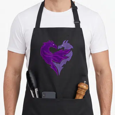 Descendant dragon apron - Two purple and lavender phoenixes mirrored to form a heart shape — shown on a black cotton canvas apron against a white background