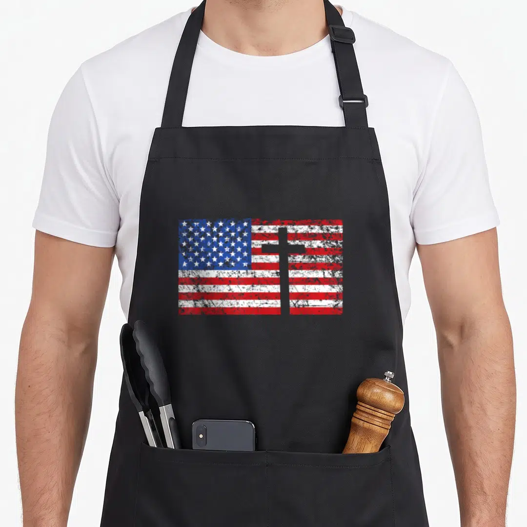 Cross christian american flag apron - Distressed USA flag with superimposed white cross in red, white, and blue — shown on a black cotton canvas apron against a white background