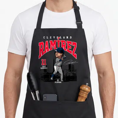 Jos ram apron - Cartoon Jose Ramirez swinging bat with Cleveland text and skyline background in red and navy — shown on a black cotton canvas apron against a white background