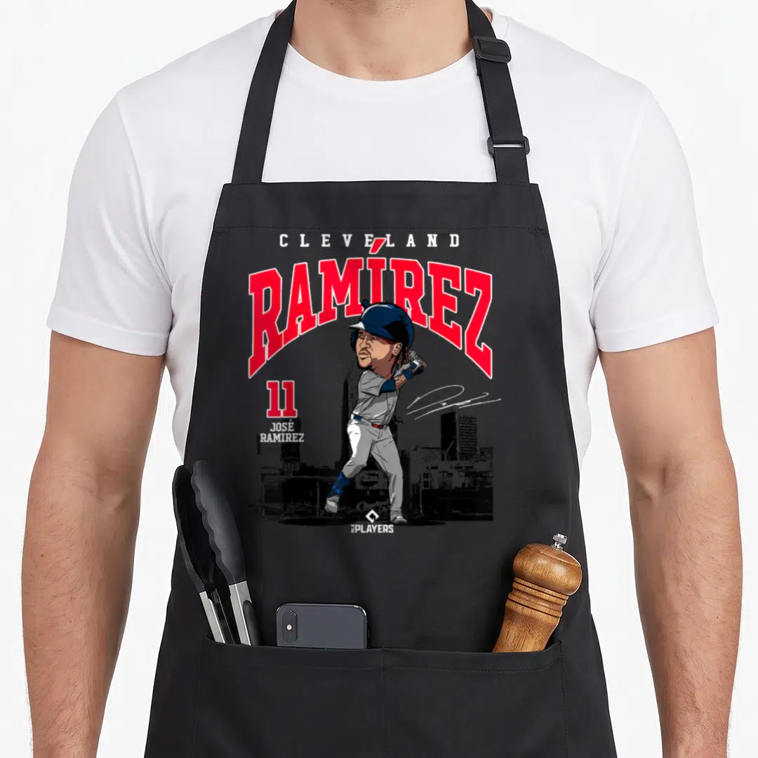 Jos ram apron - Cartoon Jose Ramirez swinging bat with Cleveland text and skyline background in red and navy — shown on a black cotton canvas apron against a white background