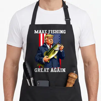 Fisherman patriotic apron - Trump holding bass in front of USA flag with Make Fishing Great Again text — shown on a black cotton canvas apron against a white background