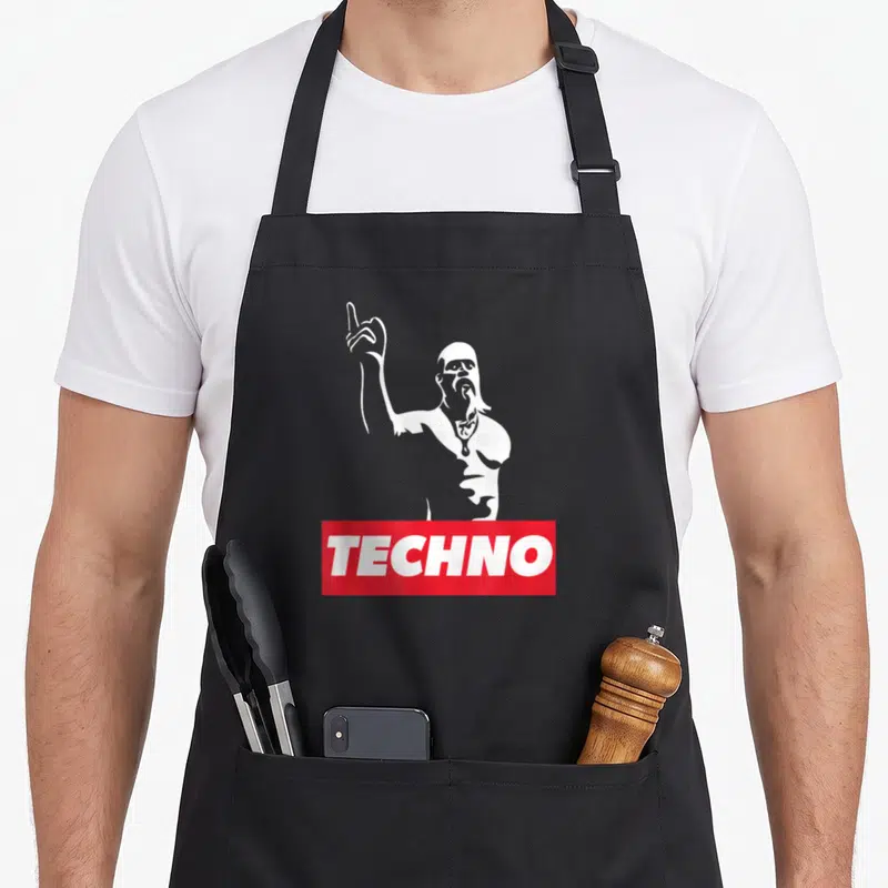 Techno viking apron - White silhouette of a man pointing up above red banner with text TECHNO — shown on a black cotton canvas apron against a white background
