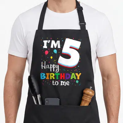 Five birthday apron - Number 5 graphic with I'M 5 Happy BIRTHDAY to me text and colorful balloons — shown on a black cotton canvas apron against a white background