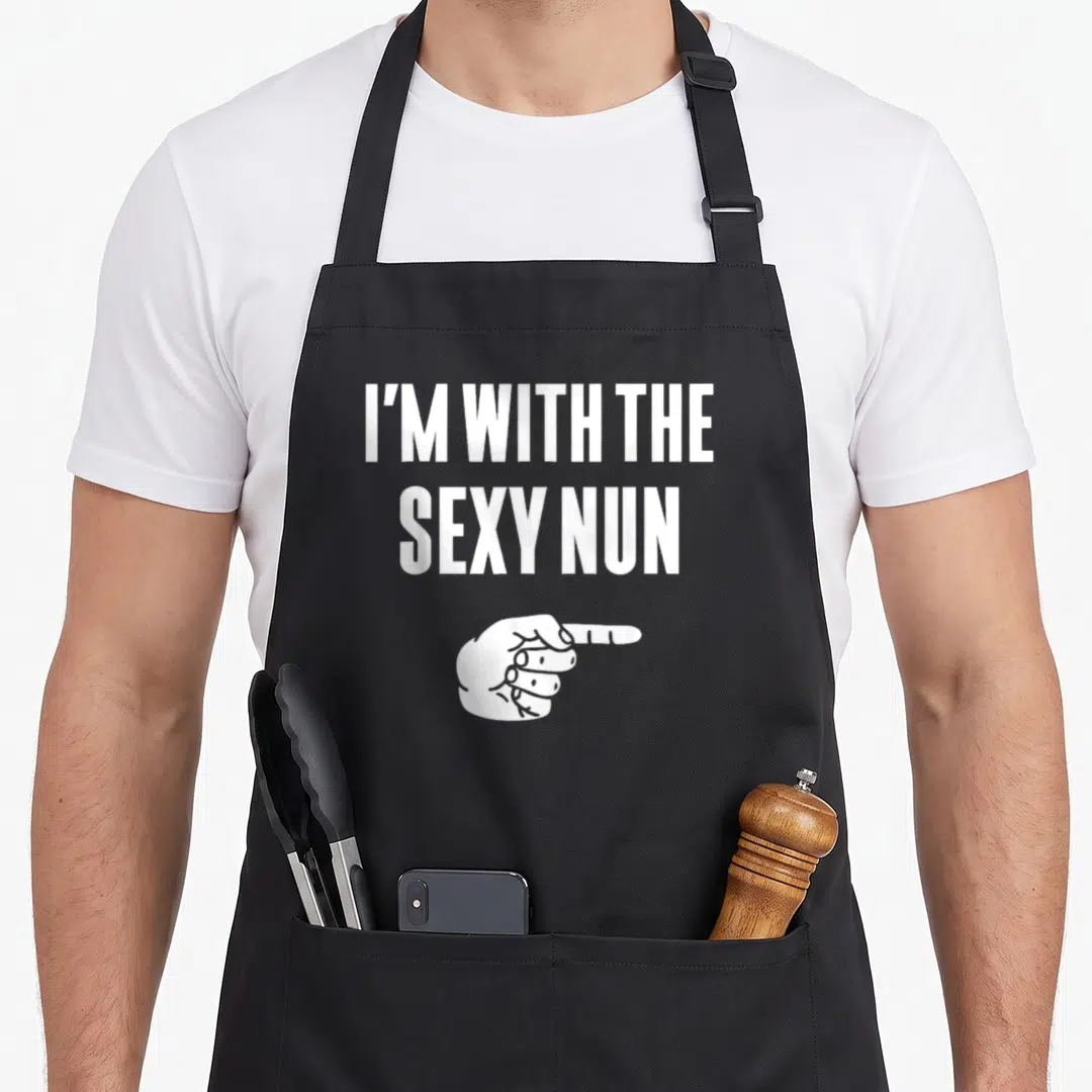 Nun halloween apron - White text I'M WITH THE SEXY NUN above a pointing hand in minimalist style — shown on a black cotton canvas apron against a white background