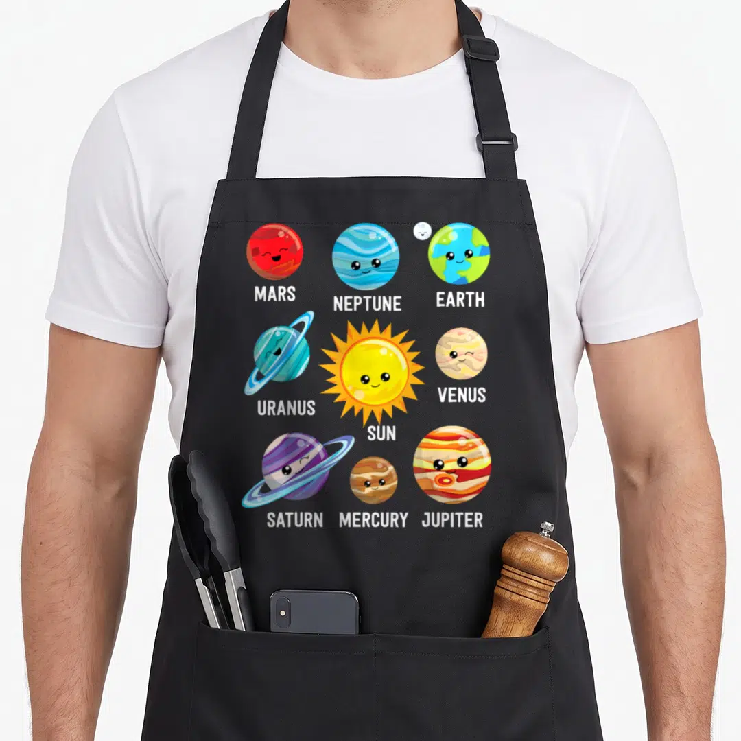 Solar space planets apron - Cartoon sun and planets labeled MARS NEPTUNE EARTH URANUS SUN VENUS SATURN MERCURY JUPITER — shown on a black cotton canvas apron against a white background