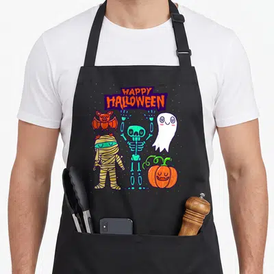 Skeleton halloween kitchen aprons - Cartoon skeleton ghost mummy bat and pumpkin under purple HAPPY HALLOWEEN banner — shown on a black cotton canvas apron against a white background