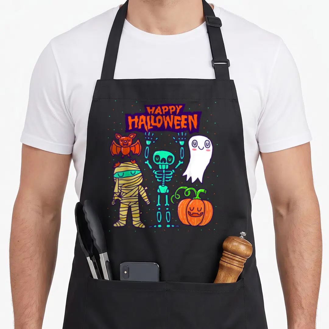 Skeleton halloween kitchen aprons - Cartoon skeleton ghost mummy bat and pumpkin under purple HAPPY HALLOWEEN banner — shown on a black cotton canvas apron against a white background
