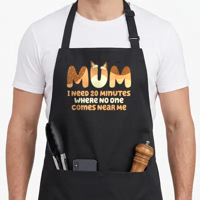 Minute mother's day aprons - MUM text with fox ears and three lines of orange and cream text reading I need 20 minutes — shown on a black cotton canvas apron against a white background