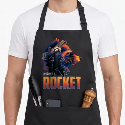 Guardian infinity apron - Rocket Raccoon full body figure holding gun in front of profile head with ROCKET text below — shown on a black cotton canvas apron against a white background