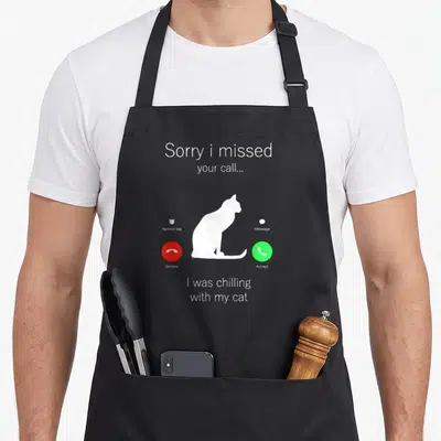 Funny kitten kitty cat apron - White cat silhouette on grey call screen with red decline and green accept buttons — shown on a black cotton canvas apron against a white background