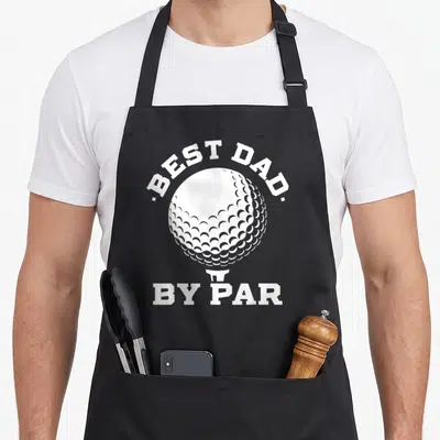 Player father day apron - White golf ball on tee with best dad by par text in minimalist style — shown on a black cotton canvas apron against a white background
