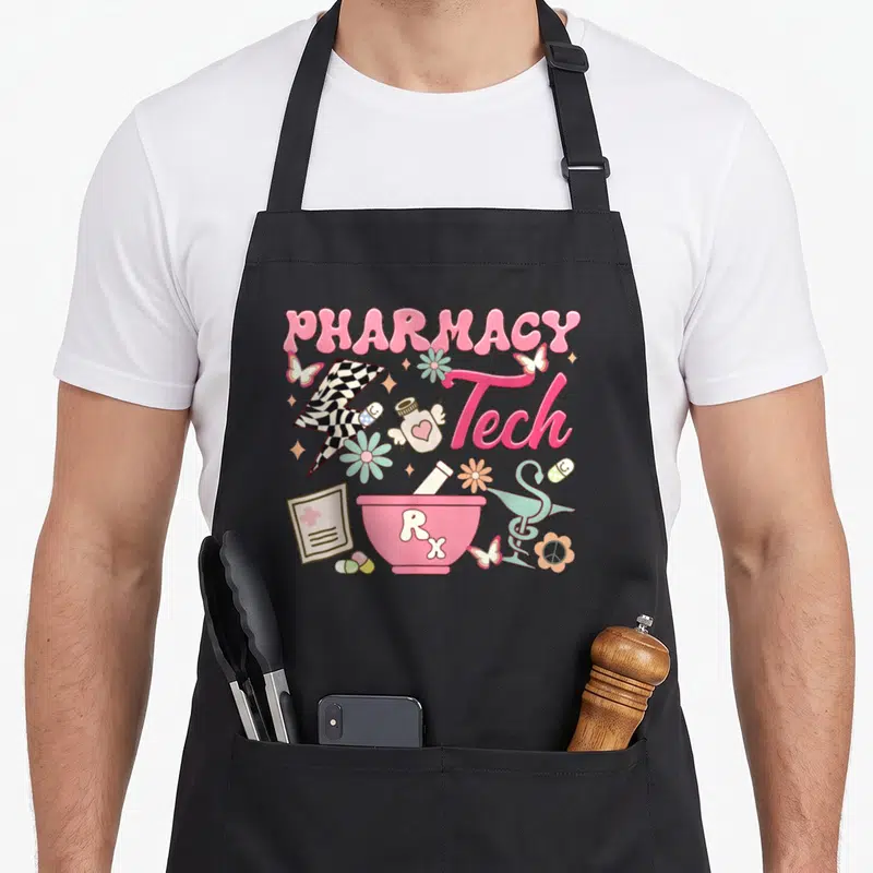 Tech pharmacist apron - PHARMACY Tech Rx text with mortar, winged bottle, peace flower, and checkered lightning bolt — shown on a black cotton canvas apron against a white background